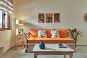 A modern living room with a sofa, a coffee table, a lamp, and wall art.