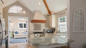 A kitchen with a large island, a built-in oven, and a window with a view.