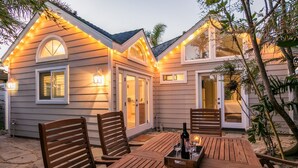 A patio area with wooden furniture and string lights.