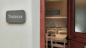 Une cuisine moderne équipée d’un évier, d’une table à manger et d’une enseigne portant l’inscription « Thalassa ».