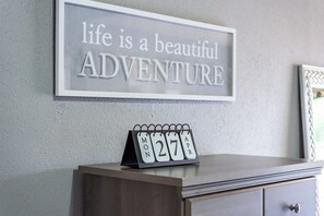 Pared con una cita motivacional, un calendario y un cuadro enmarcado.