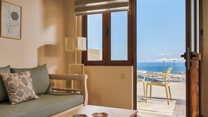 Une pièce avec un canapé, une table et une vue sur la plage.