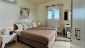 A bedroom with a bed, nightstand, lamp, and a window with curtains. - "Villa Caress" - Spacious villa with private pool and sea view (Malevizi)