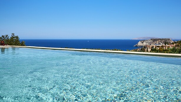 A clear pool with a view of the sea and a rocky coastline. - "Villa Caress" - Spacious villa with private pool and sea view (Malevizi)