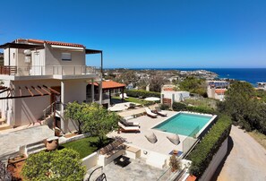 Une villa moderne dotée d’une piscine, d’un espace extérieur aménagé et offrant une vue sur la mer.
