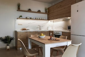 A modern kitchen with wooden cabinets, a marble countertop, and a built-in island with seating.