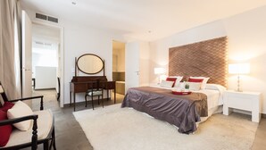 Une chambre à coucher moderne avec un lit, des tables de chevet, un bureau et une chaise.