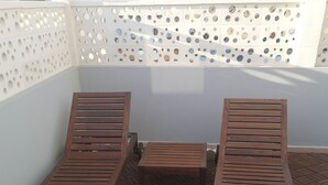 A rooftop terrace with two wooden lounge chairs and a small table. - Morisca Lapiada House (Morro Jable)