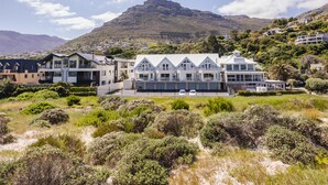 Een modern hotel met een groot, meerlaags gebouw, een opvallend balkon en uitzicht op een berg.