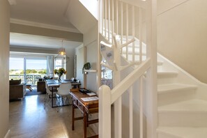 A spacious living area with a dining table, chairs, and a view of the outdoors. - Cape Town Townhouse. Panoramic Sea & Mountain Views. Beach 50m. Spectacular! (Cape Town)
