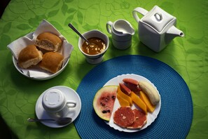 A breakfast setting with bread, jam, a teapot, and a plate of fruit. - Hostal Dr Amaro y Dra Yamira (Trinidad)