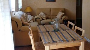 A living room with a beige sofa, a wooden coffee table, and a painting on the wall. - "EL TRASTERO" Penthouse, cozy, bright and quiet (Santa Marta de Tormes)