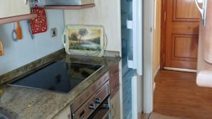 A compact kitchen with a gas stove, a refrigerator, and a microwave. - "EL TRASTERO" Penthouse, cozy, bright and quiet (Santa Marta de Tormes)