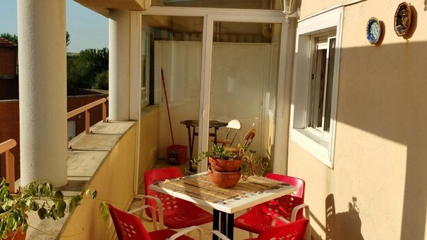 A small outdoor patio with a table and chairs, a potted plant, and a window. - "EL TRASTERO" Penthouse, cozy, bright and quiet (Santa Marta de Tormes)