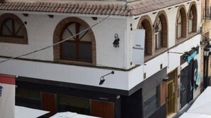 A building with a white facade, arched windows, and a sign that reads "Hotel Manhattan." - Alicante center, beach and lively area Wifi Air-conditioning (Alacant)