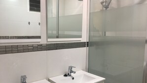 A bathroom with two sinks, a mirror, and a glass shower enclosure. - Alicante center, beach and lively area Wifi Air-conditioning (Alacant)