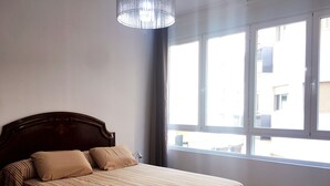 A bedroom with a bed, a window, and a hanging light fixture. - Alicante center, beach and lively area Wifi Air-conditioning (Alacant)