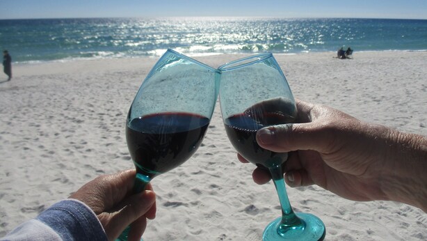 Two hands holding wine glasses on a beach with the ocean in the background. - Quiet Island getaway 30% off Fall/Winter stays! Private Fishing Pier, PERFECT! (Navarre)
