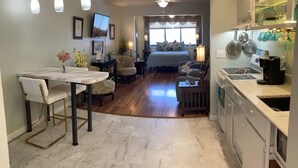 A spacious kitchen with a dining area, a bedroom with a large window, and a ceiling fan. - Quiet Island getaway 30% off Fall/Winter stays! Private Fishing Pier, PERFECT! (Navarre)