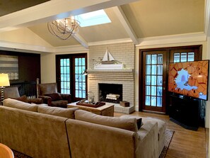 A spacious living room with a large sectional sofa, a fireplace, and a television.