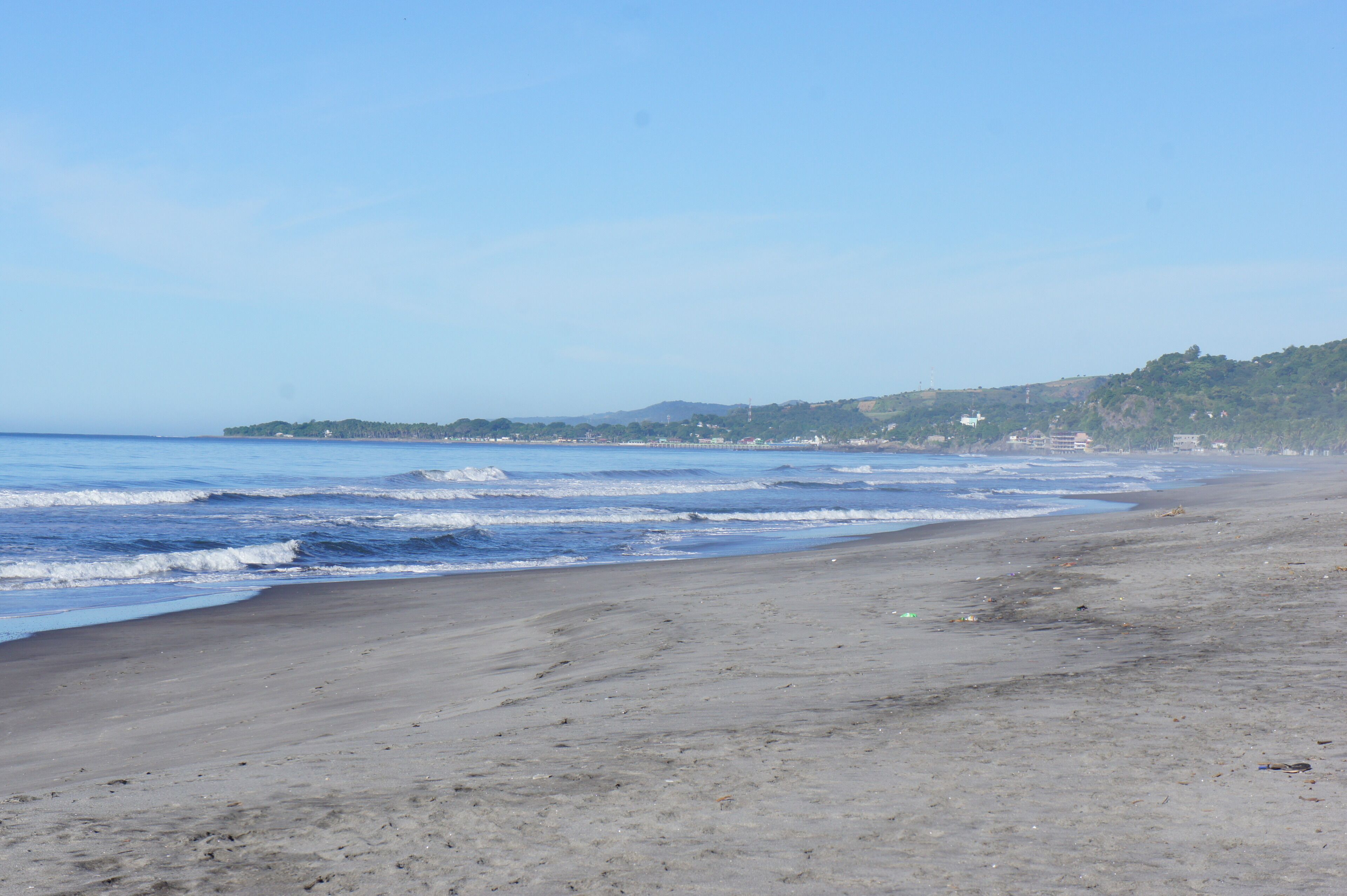 Ein Strand mit sandigem Ufer und Wellen.