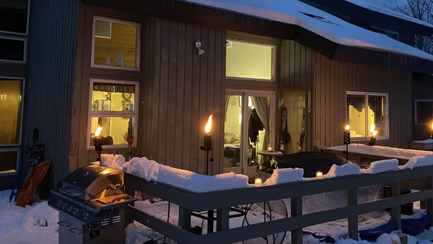 A wooden house with a covered patio, a grill, and a hot tub. - Beautiful 3 BR ski In Trailside condo.  Steps away from WaterPark & Ice Rink  (Jay)