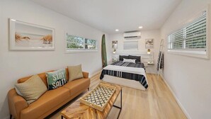 Ein modernes Schlafzimmer mit einem Bett, einem Sofa und einem Couchtisch.