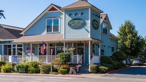 A two-story building with a porch, a sign reading "Tillinghast Seed Co.", and a flag. - La Conner, Tillinghast Residence E #401 (La Conner)