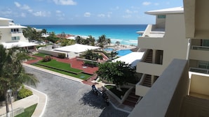 Un resort con piscina, palmeras y vista al océano.