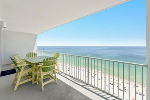 A balcony with a view of the beach and ocean.