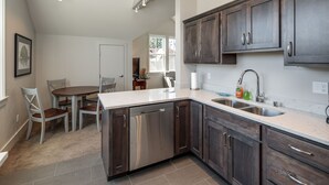 A modern kitchen with dark wood cabinets, stainless steel appliances, and a marble countertop. - La Conner, Tillinghast Residence A #400 (La Conner)