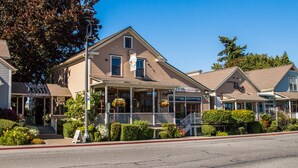 A traditional two-story building with a porch, a sign indicating a bistro and bar, and a sign for seeds open. - La Conner, Tillinghast Residence A #400 (La Conner)