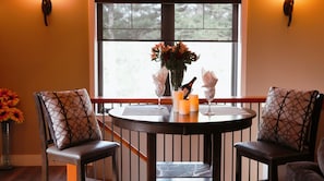 Enjoy a romantic dinner for two in this serene dining area with a view of the surrounding trees.