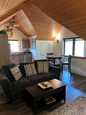 Een loft met een hoge ruimte, een eethoek en een keuken.
