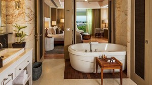 A modern bathroom with a freestanding bathtub, a vanity with a mirror, and a small table with toiletries. - Three bed loft at Private Residence Club (Playa del Carmen)