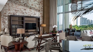 A modern living room with a large TV, comfortable seating, a dining area, and a view of the city. - Three bed loft at Private Residence Club (Playa del Carmen)