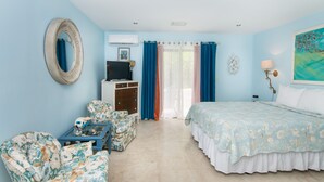 Un dormitorio con cama, televisor, escritorio y silla.