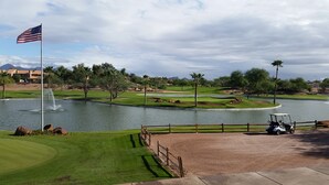 A golf course with a flag, water hazards, and a golf cart. - Relax in beautiful and quiet Scottsdale condo. Heated pool/hot tub (Scottsdale)