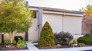 A building with a modern design, featuring a well-maintained garden with various plants and flowers.