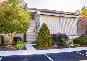 A building with a modern design, featuring a well-maintained garden with various plants and flowers.