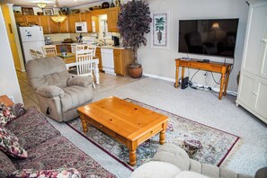 A living room with a sofa, a wooden coffee table, and a television.