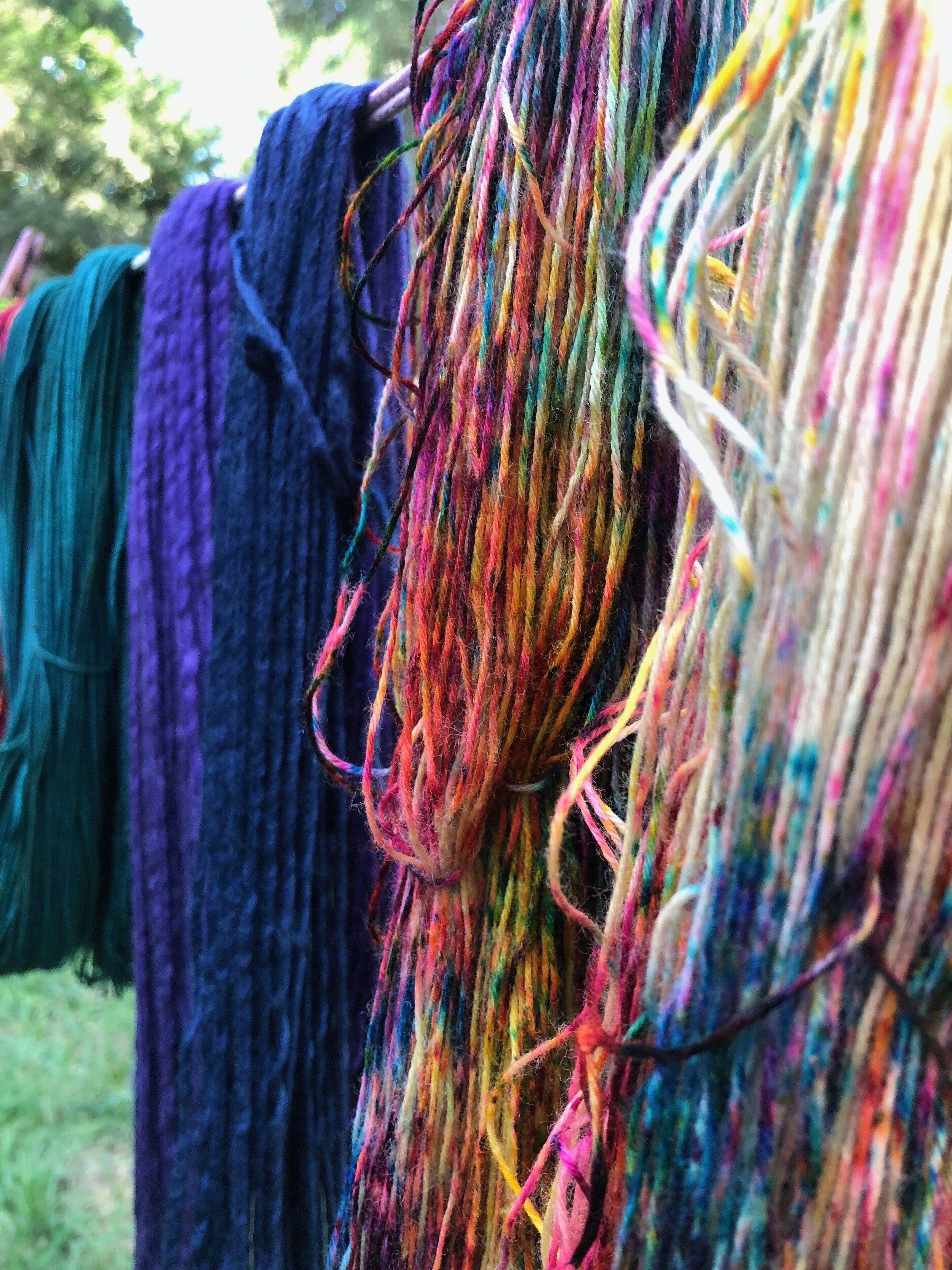 A close-up of colorful yarns hanging.