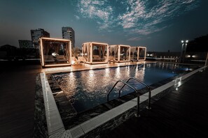 A pool area with multiple sun loungers and a poolside bar. - Kwarleyz Residence Hotel & Suites (Accra)