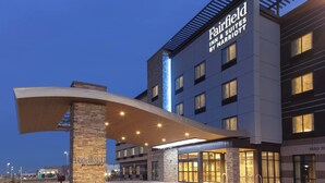 Ein moderner Hotel Eingang mit einer auffälligen Schilderung, einem überdachten Gang und einer gut beleuchteten Fassade.