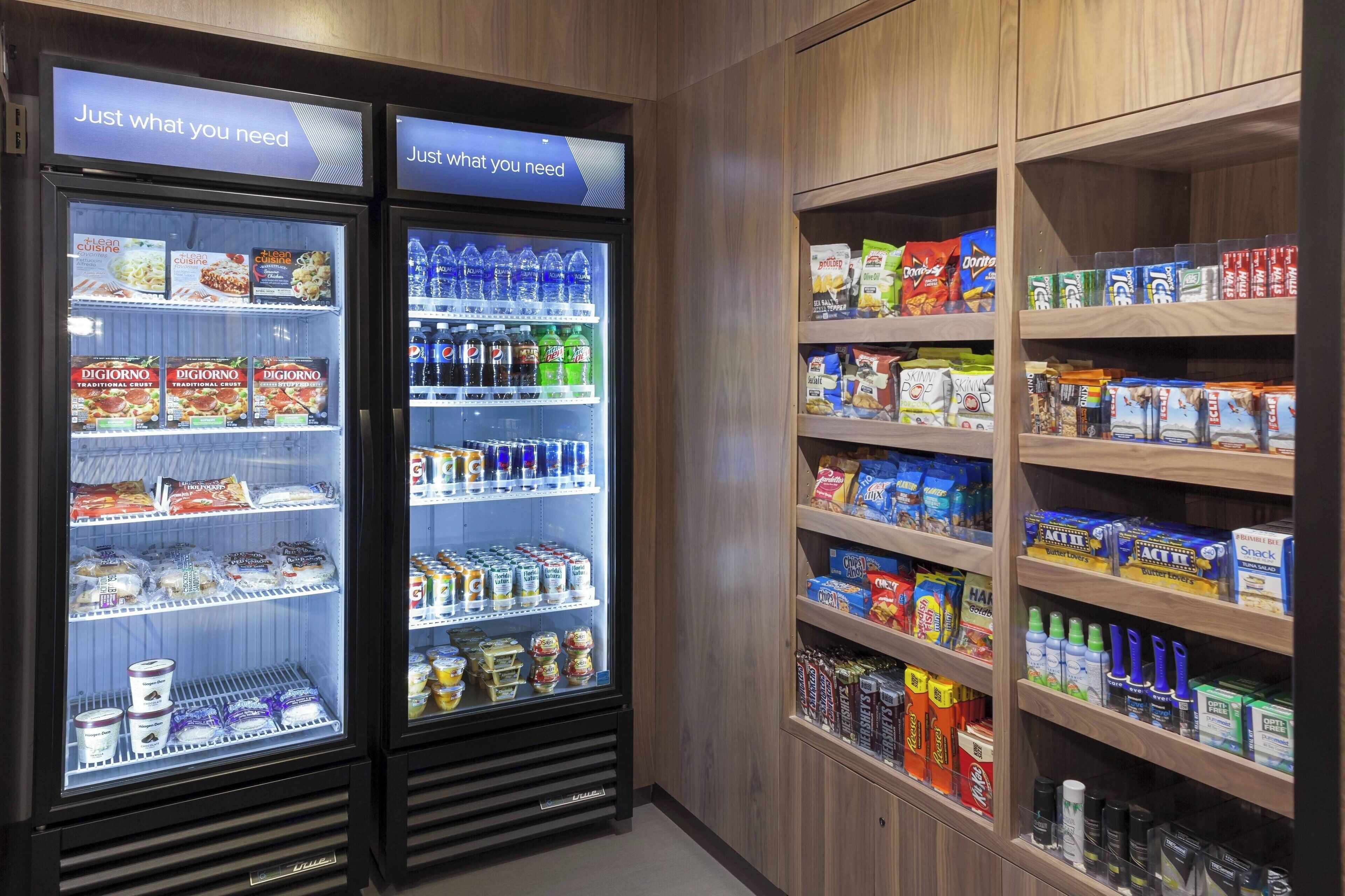 Two refrigerated display cases stocked with food and beverages, and adjacent shelves with snacks and household items.