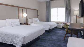 A hotel room with two beds, a desk, a chair, a TV, and a window with curtains.