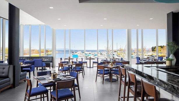 Ein modernes Restaurant mit großen Fenstern und Blick auf eine Marina.