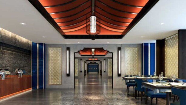 Un moderno vestíbulo de hotel con piso de mármol, un mostrador de recepción y un comedor con mesas y sillas.