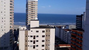 A coastal cityscape with high-rise buildings and a clear view of the ocean. - 100m da Praia Aviação Imperdível (Praia Grande)