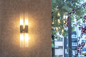 Un luminaire mural fixé au mur, doté de deux lampes verticales sur un mur à texture.